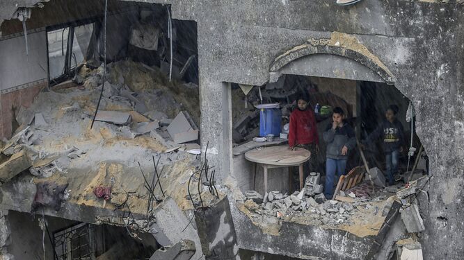 Niños palestinos observan el hueco provocado en su vivienda por los bombardeos en Deir Al Balah, en el sur de la Franja.