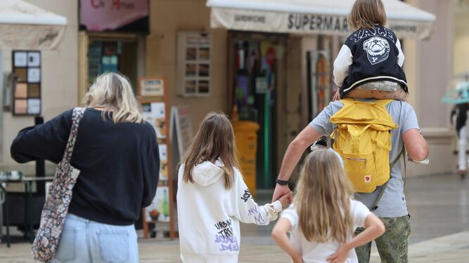 Una familia pasea con sus hijos por el centro de Málaga.
