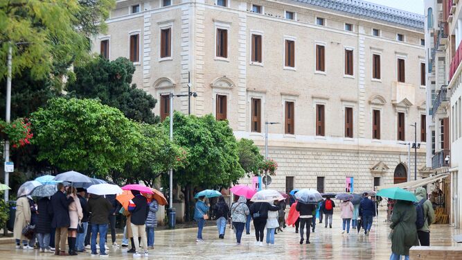 Personas se protegen de la lluvia con paraguas.