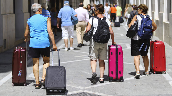Turistas con maletas por las calles de Málaga.