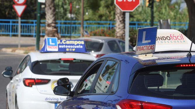 Dos coches de autoescuelas de Málaga durante una examinación.